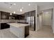 Kitchen boasts stainless steel appliances, dark cabinets, a white island, and wood-look tile flooring at 5518 Taylor Rose Ave, Las Vegas, NV 89139