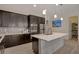 Well-equipped kitchen with stainless steel appliances, dark cabinetry, and a white island with a view of the pantry at 5518 Taylor Rose Ave, Las Vegas, NV 89139