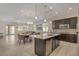 Open-concept kitchen with dark cabinets, a white quartz island, and stainless steel appliances with an adjacent dining area at 5518 Taylor Rose Ave, Las Vegas, NV 89139