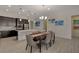 This open kitchen, dining, and living room features stainless steel appliances, dark cabinetry, and a large island at 5518 Taylor Rose Ave, Las Vegas, NV 89139