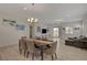 Open-concept living and dining area with wood-look tile flooring and a sliding glass door to the backyard at 5518 Taylor Rose Ave, Las Vegas, NV 89139