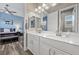 Bright bathroom with double sink vanity, white cabinets, granite countertop and modern fixtures at 5523 Taylor Rose Ave, Las Vegas, NV 89139