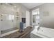 Bright primary bath featuring a glass shower, soaking tub, and hardwood floors at 5523 Taylor Rose Ave, Las Vegas, NV 89139