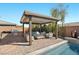 Stylish covered patio adjacent to pool includes BBQ area, seating, and firepit for outdoor enjoyment at 5523 Taylor Rose Ave, Las Vegas, NV 89139