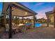 Chic outdoor living space with a pool, spa, and covered patio area featuring a built-in fire pit at 5523 Taylor Rose Ave, Las Vegas, NV 89139