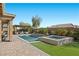 A backyard oasis features a sparkling pool, spa, fire pit, and covered lounge area with comfortable seating at 5523 Taylor Rose Ave, Las Vegas, NV 89139