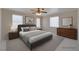 This staged bedroom features neutral tones, a ceiling fan, and natural light from the windows at 5854 Heather Marie Dr, Las Vegas, NV 89110