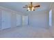This is an empty bedroom with three doors, one window, a ceiling fan, and carpet floors at 5854 Heather Marie Dr, Las Vegas, NV 89110