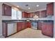 Well-lit kitchen with stainless steel appliances, cherry cabinets, and tile flooring at 5854 Heather Marie Dr, Las Vegas, NV 89110