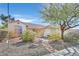 Charming single-story home featuring a well-maintained front yard with desert landscaping and mature trees at 6151 Naha Port Ave, Las Vegas, NV 89110