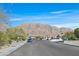 Wide street view with mountain backdrop and lush landscaping, enhancing the neighborhood's appeal at 6151 Naha Port Ave, Las Vegas, NV 89110