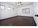 Bright bedroom with wood-look floors, three windows, and a ceiling fan; perfect for relaxation at 6440 N Bruce St, North Las Vegas, NV 89086