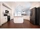 Open-concept kitchen with white cabinets, stainless steel refrigerator, black appliances, and dark wood flooring at 6440 N Bruce St, North Las Vegas, NV 89086