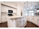 Bright kitchen with white cabinets, black hardware, pendant lighting and dark wood flooring at 6440 N Bruce St, North Las Vegas, NV 89086