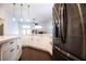 Modern kitchen featuring stainless steel refrigerator, white cabinets and dark wood flooring at 6440 N Bruce St, North Las Vegas, NV 89086