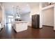 Bright and open kitchen with white cabinets, a center island, stainless steel appliances and dark wood floors at 6440 N Bruce St, North Las Vegas, NV 89086
