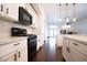 A modern kitchen with white cabinets, black appliances and dark wood flooring at 6440 N Bruce St, North Las Vegas, NV 89086