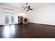 Spacious living room with a fireplace, media shelving, high ceilings with fan, and sliding glass doors at 6440 N Bruce St, North Las Vegas, NV 89086