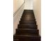 View of a dark wood staircase with a stainless handrail in a neutrally decorated home at 7139 S Durango Dr # 218, Las Vegas, NV 89113