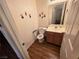 Cozy half bathroom with a single sink vanity, toilet with safety handles, and decorative wall art at 7209 London Bridge Ave, Las Vegas, NV 89130