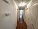 Long hallway with multiple doors on either side, featuring wood floors and recessed lighting at 7209 London Bridge Ave, Las Vegas, NV 89130