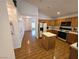 Well-equipped kitchen featuring oak cabinets, laminate flooring, central island, and modern appliances at 7209 London Bridge Ave, Las Vegas, NV 89130