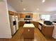 Functional kitchen with a central island, oak cabinets, white countertops, and modern appliances at 7209 London Bridge Ave, Las Vegas, NV 89130