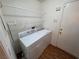 Functional laundry room equipped with a washer, dryer, storage shelves, and convenient access to outside at 7209 London Bridge Ave, Las Vegas, NV 89130