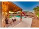Covered patio area with outdoor furniture overlooking a sparkling pool and lush backyard at 8240 Campana Dr, Las Vegas, NV 89147