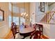 Elegant dining room featuring a chandelier, large table, and staircase access at 8240 Campana Dr, Las Vegas, NV 89147