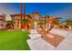 Beautiful two-story home featuring desert landscaping, a well-manicured lawn, and mature palm trees at 8240 Campana Dr, Las Vegas, NV 89147