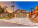 Two-story home features a spacious three-car garage, desert landscaping, and mature trees at 8240 Campana Dr, Las Vegas, NV 89147
