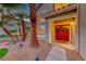 Inviting front entry with red double doors, decorative wreaths, and desert landscaping at 8240 Campana Dr, Las Vegas, NV 89147