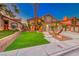 Well-manicured front yard featuring green grass, palm trees, and attractive desert landscaping at 8240 Campana Dr, Las Vegas, NV 89147