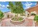Beautiful backyard with a mature tree, brick-lined garden, and a covered patio at 8624 Burning Hide Ave, Las Vegas, NV 89143