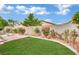 Landscaped backyard with brick patio, grass area and planter beds at 8624 Burning Hide Ave, Las Vegas, NV 89143