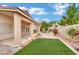 Landscaped backyard with well-maintained lawn, brick accents, and a covered patio at 8624 Burning Hide Ave, Las Vegas, NV 89143