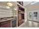 Elegant bar featuring granite counters, mirrored shelving, and a built-in mini-fridge at 8624 Burning Hide Ave, Las Vegas, NV 89143