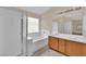 Bright bathroom featuring double vanity, bathtub, and enclosed shower at 8624 Burning Hide Ave, Las Vegas, NV 89143