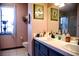 Bathroom vanity featuring dual sinks, black fixtures and decorative framed artwork at 9113 Anchor Cove Ct, Las Vegas, NV 89117