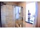 Elegant shower with glass door and tile walls next to a window with a flower at 9113 Anchor Cove Ct, Las Vegas, NV 89117