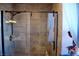 Tiled shower with glass doors with brushed nickel shower fixtures and a small corner shelf at 9113 Anchor Cove Ct, Las Vegas, NV 89117