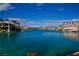 Expansive waterfront view with luxurious homes, palm trees, and clear blue water, creating a tranquil setting at 9113 Anchor Cove Ct, Las Vegas, NV 89117