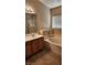 Bathroom featuring a soaking tub with tile surround and a vanity with solid surface countertops at 10524 Congaree St, Las Vegas, NV 89141