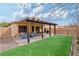 Spacious backyard with covered patio, grill, and artificial turf area offers a low-maintenance outdoor space at 11007 Vallerosa St, Las Vegas, NV 89141