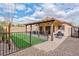 Inviting backyard featuring a covered patio, faux grass, and rock landscaping perfect for outdoor enjoyment at 11007 Vallerosa St, Las Vegas, NV 89141