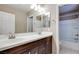 Bright bathroom featuring double sink vanity with dark wood cabinets and a shower-tub combo at 1427 Brushback Ave, Henderson, NV 89074