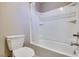 Clean white bathtub and shower combo with a white shower curtain and a low-flow toilet at 1427 Brushback Ave, Henderson, NV 89074