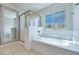 Bright bathroom with a soaking tub, separate shower, and a large decorative mirror enhancing the space at 1427 Brushback Ave, Henderson, NV 89074