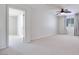 Large, empty bedroom with neutral carpet, a ceiling fan and views of another room at 1427 Brushback Ave, Henderson, NV 89074